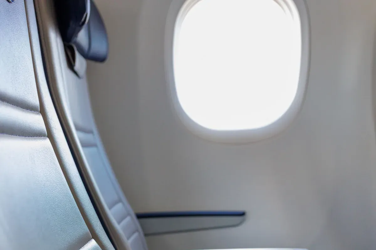 Un posto finestrino d'aereo con la luce del giorno che entra in cabina