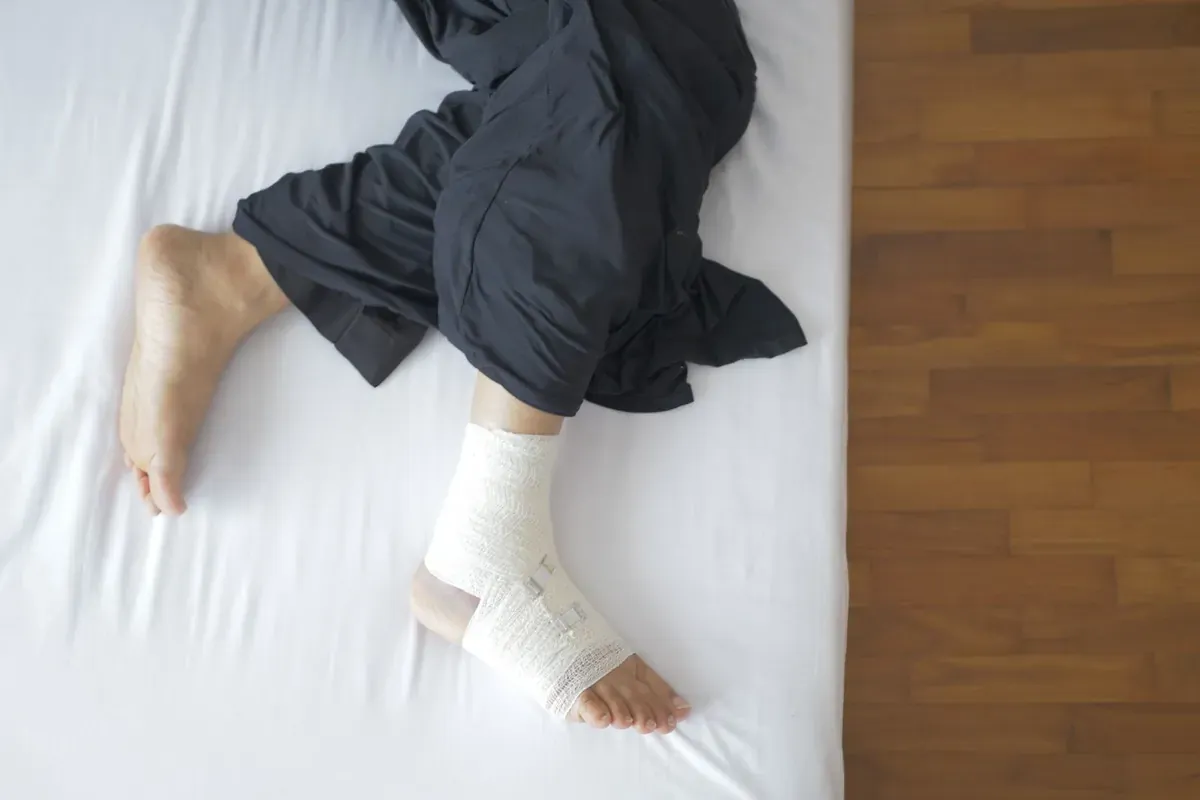 Un piede fasciato appoggiato su un letto