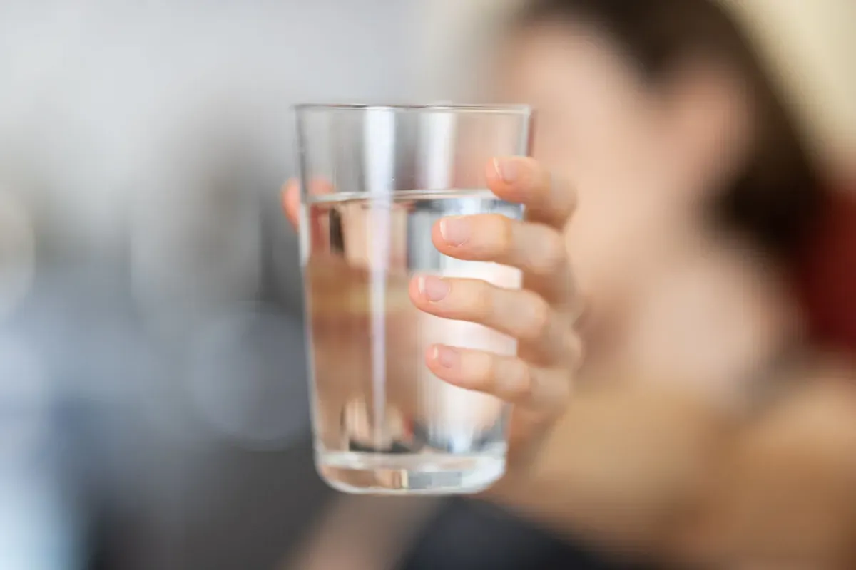 Una mano che regge un bicchiere d'acqua