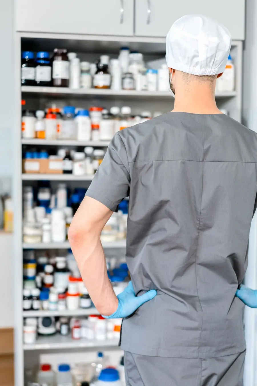 Un farmacista prepara i farmaci davanti agli scaffali