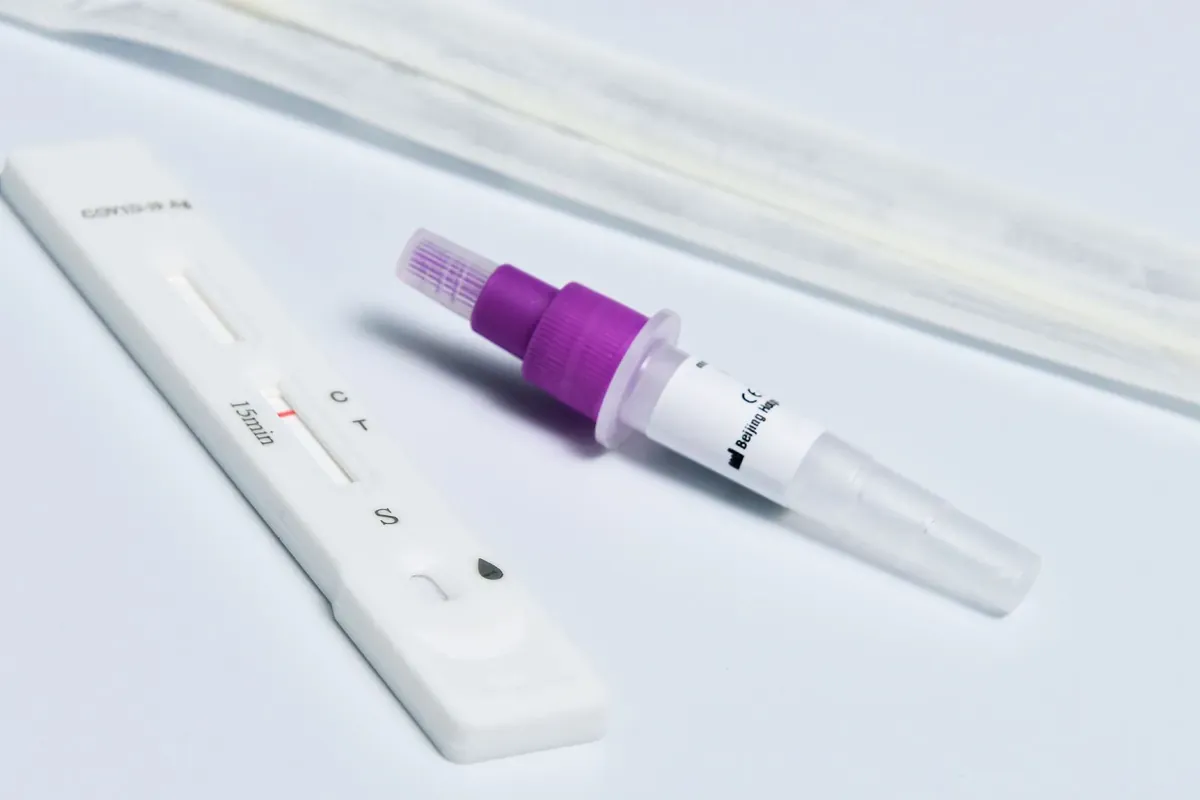 Una cassetta per test antigenico rapido e un tampone su una superficie bianca