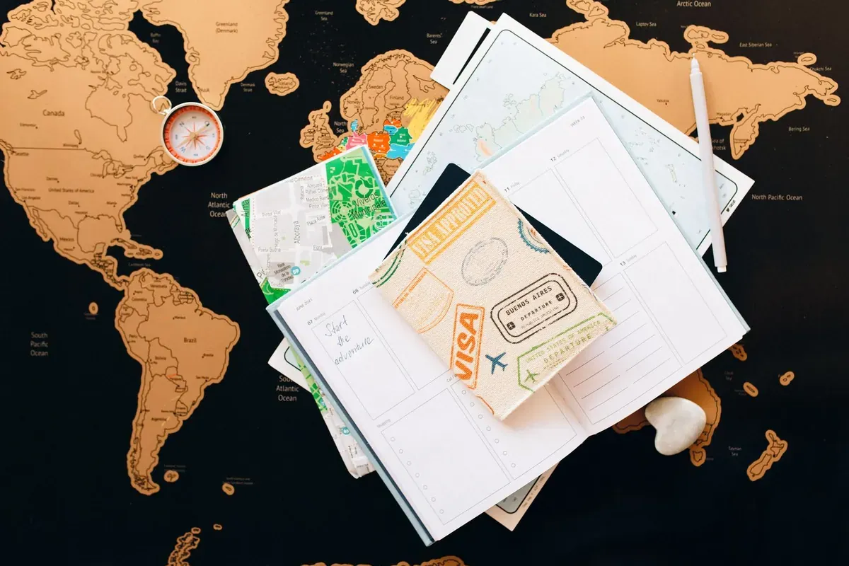 Documenti di viaggio e un passaporto stesi su una cartina